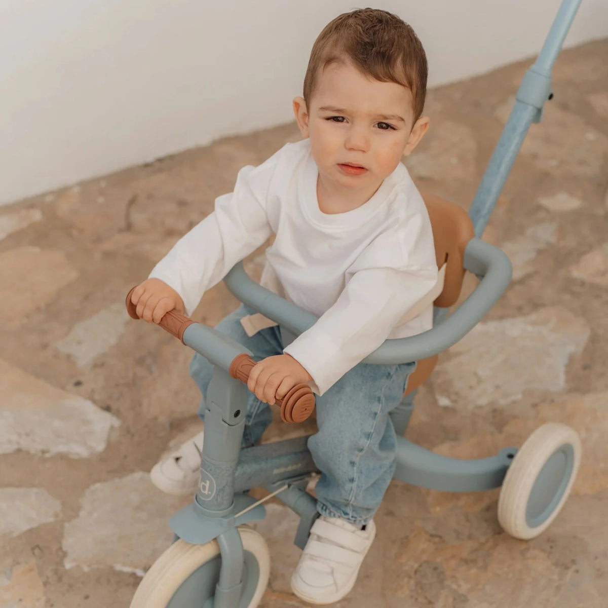 Kind fährt das Little Dutch Tricycle 4-in-1 in Blau mit Schubstange. Das wandelbare Dreirad und Laufrad fördert Balance, Koordination und Motorik für Kinder ab 1 Jahr.